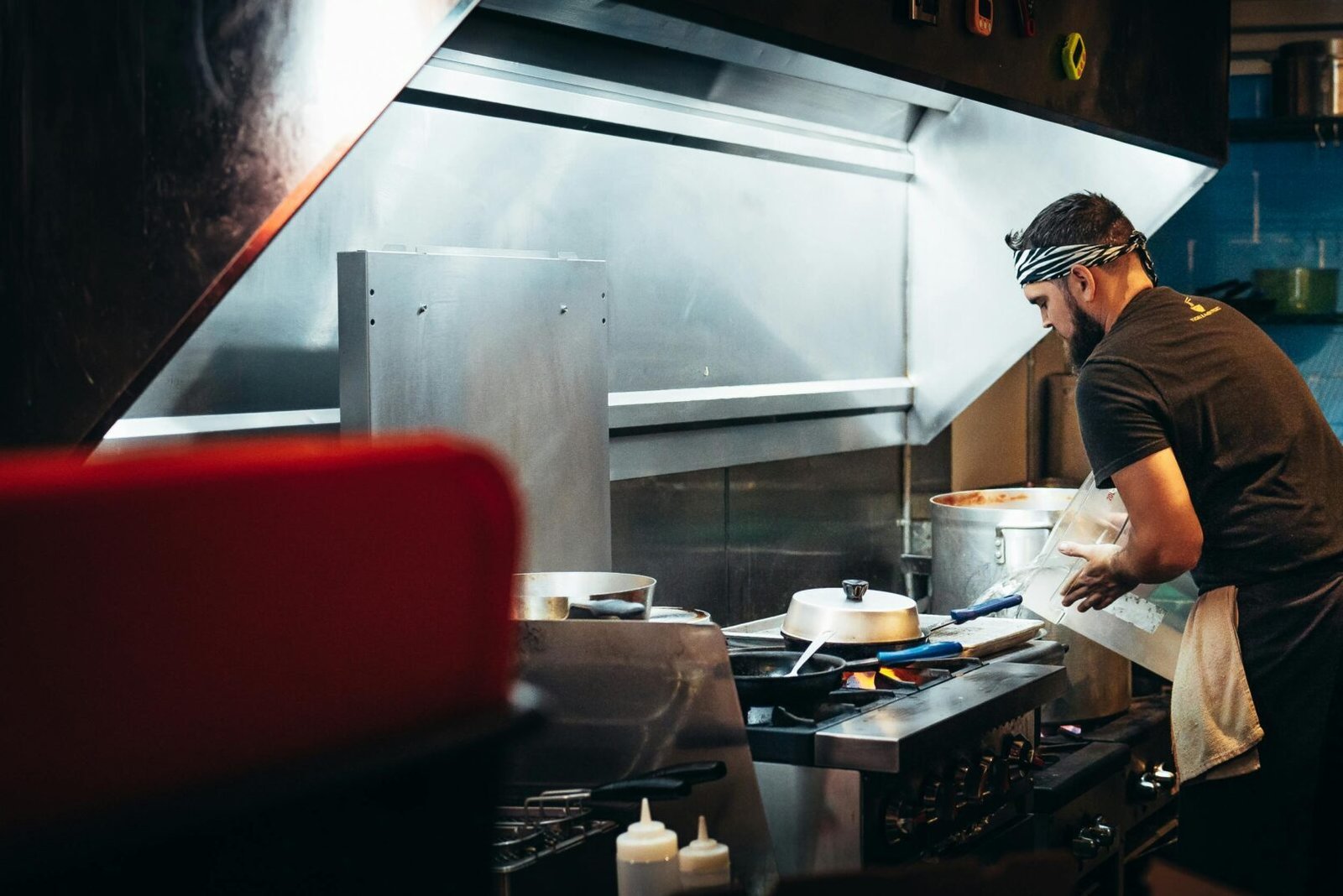 Two chefs preparing meals in a bustling restaurant kitchen, focused on culinary tasks.